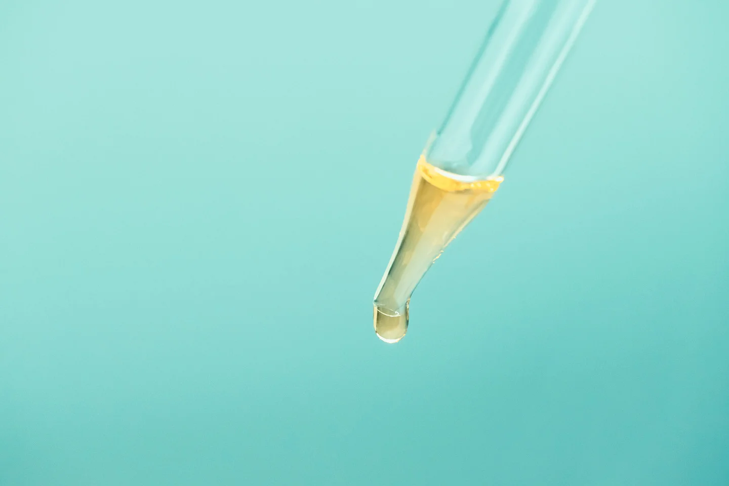 Glass pipette with cosmetic oil essence close up